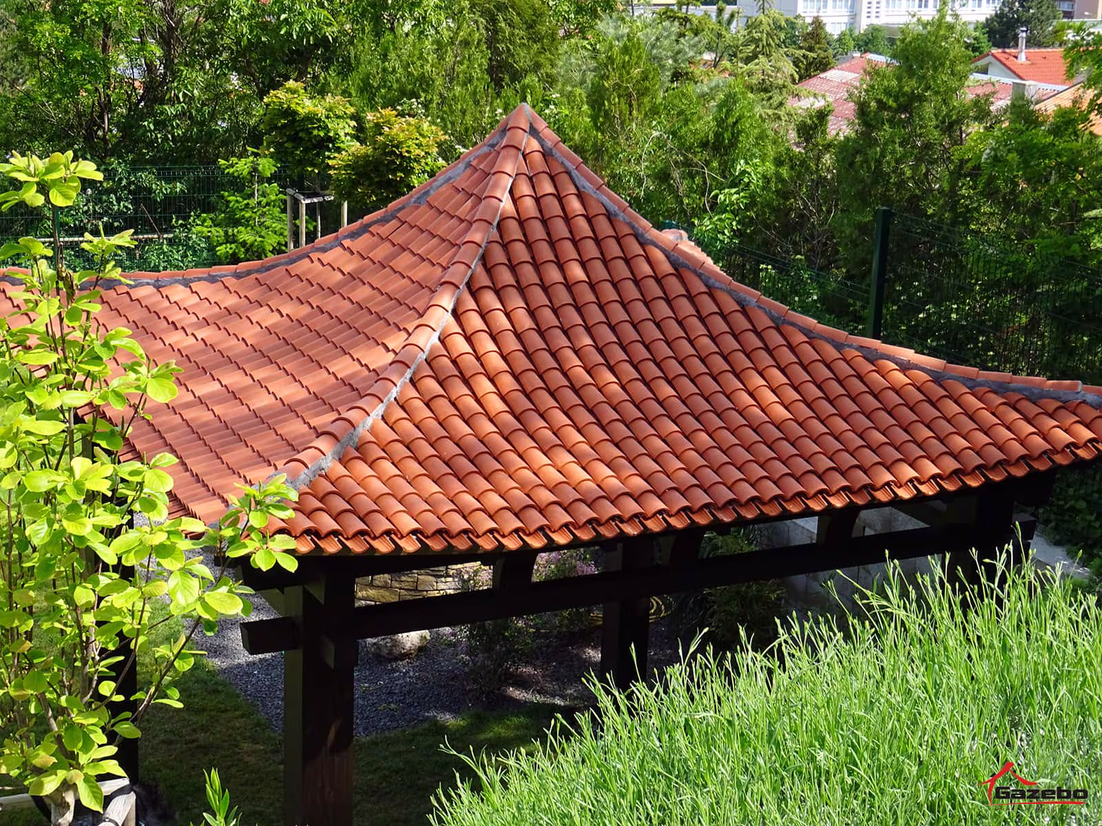 Hinode fa kerti pavilon kerámiatetővel egy családi ház kertjében