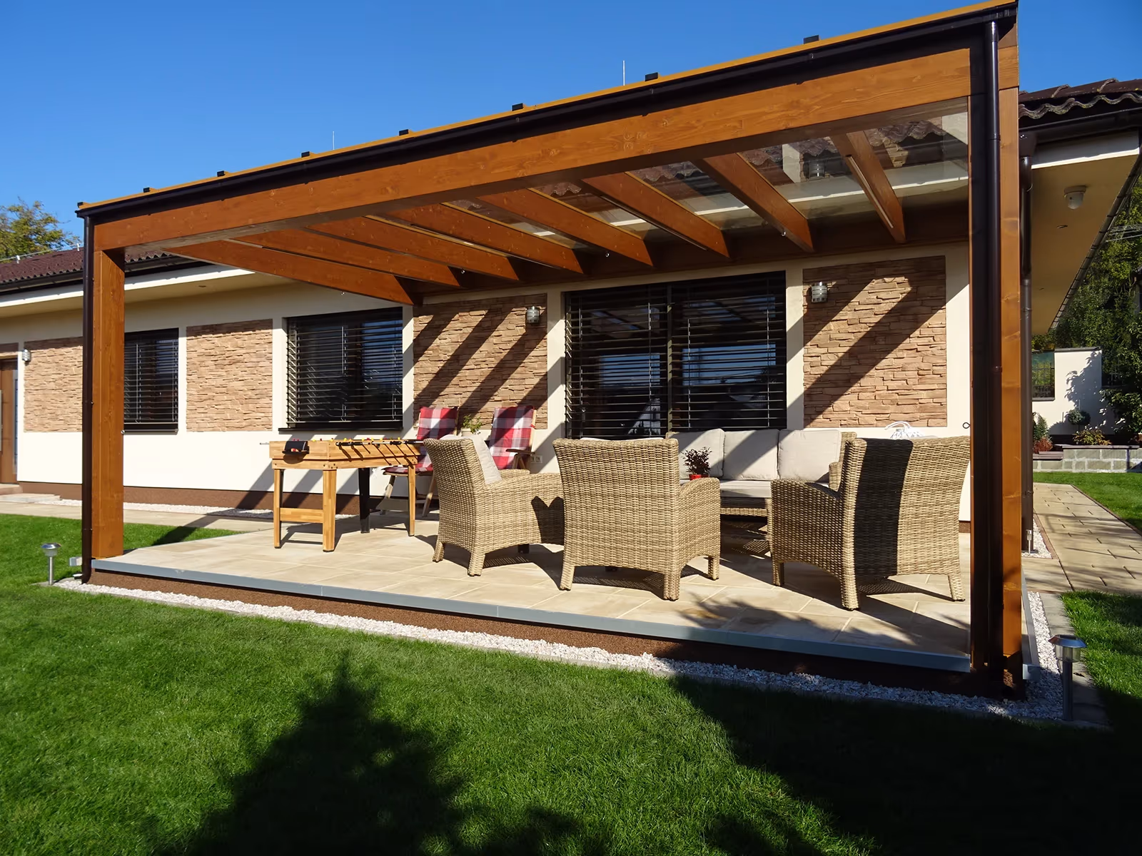Milano fa pergola étkezőgarnitúrával egy kőházhoz épített teraszon